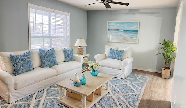 living area with ceiling fan, baseboards, and wood finished floors