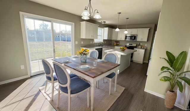 dining room with a notable chandelier, dark hardwood / wood-style floors, and sink