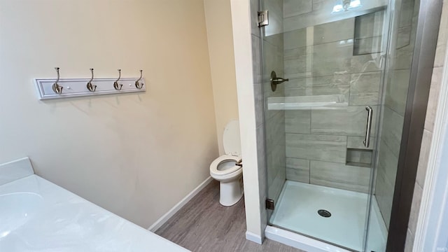 bathroom featuring an enclosed shower, toilet, and wood-type flooring