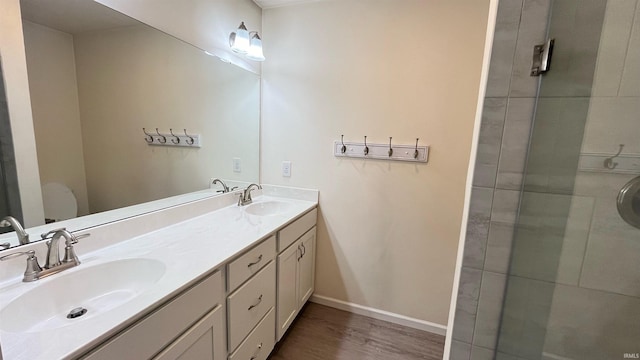 bathroom with hardwood / wood-style floors, vanity, and a shower with door