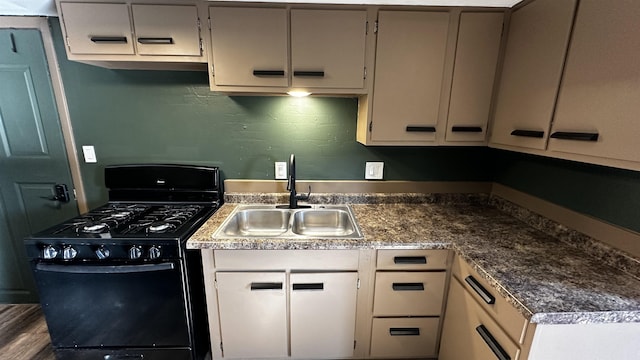 kitchen with black range with gas stovetop, cream cabinets, and sink