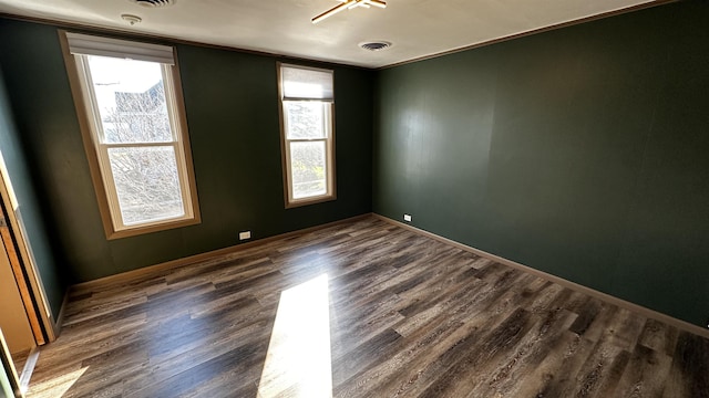 empty room with dark hardwood / wood-style floors and ornamental molding