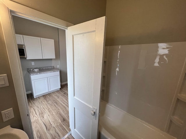 bathroom featuring wood-type flooring and shower / bathtub combination