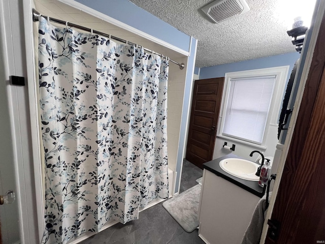 bathroom with vanity, shower / bath combo with shower curtain, and a textured ceiling