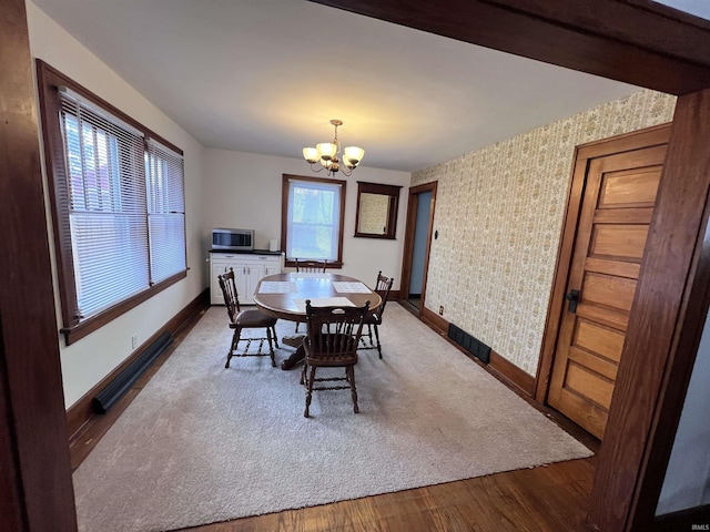 dining area featuring hardwood / wood-style floors, a wealth of natural light, and a notable chandelier