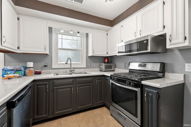 kitchen featuring a textured ceiling, white cabinetry, sink, and appliances with stainless steel finishes