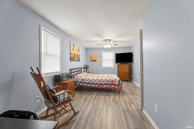 bedroom featuring multiple windows, light hardwood / wood-style floors, and ceiling fan