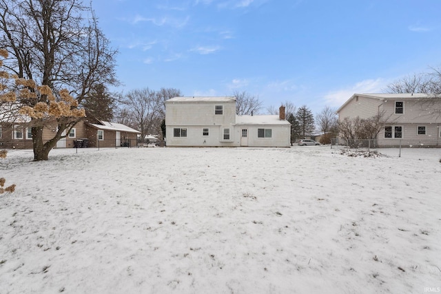 view of snow covered back of property