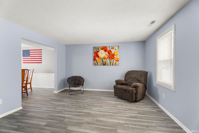 sitting room featuring light hardwood / wood-style flooring, a healthy amount of sunlight, and a textured ceiling