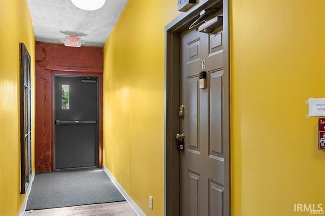 corridor featuring a textured ceiling and light wood-type flooring