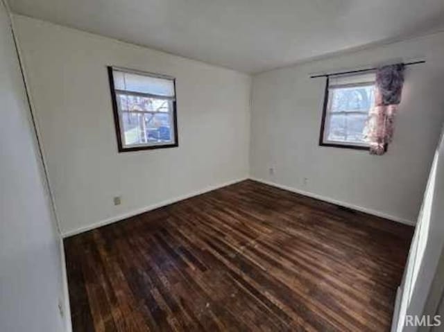 spare room with dark hardwood / wood-style floors