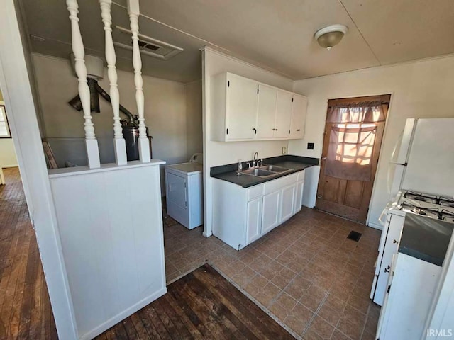 kitchen with sink, white cabinets, white appliances, and washer / dryer