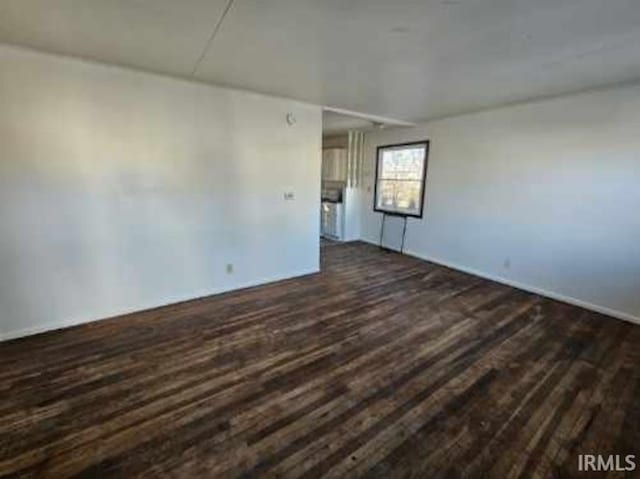 unfurnished room with dark hardwood / wood-style flooring