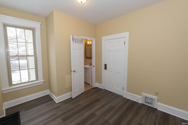 unfurnished room featuring sink and dark wood-type flooring