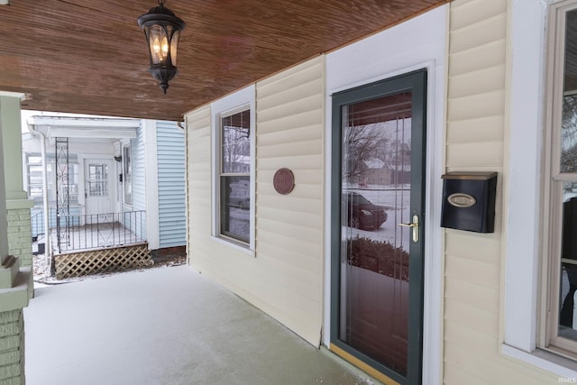 view of exterior entry featuring covered porch