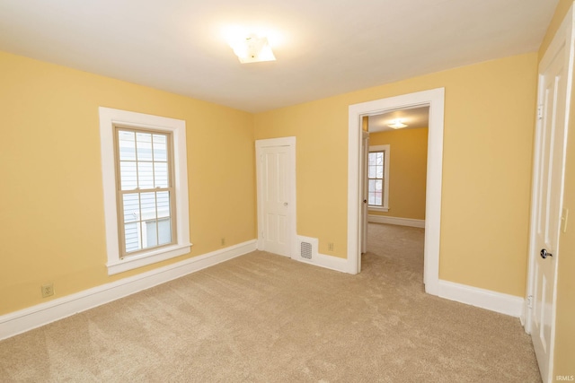 unfurnished bedroom with light carpet and a closet