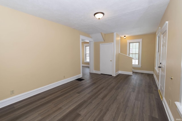 empty room with plenty of natural light and dark hardwood / wood-style floors