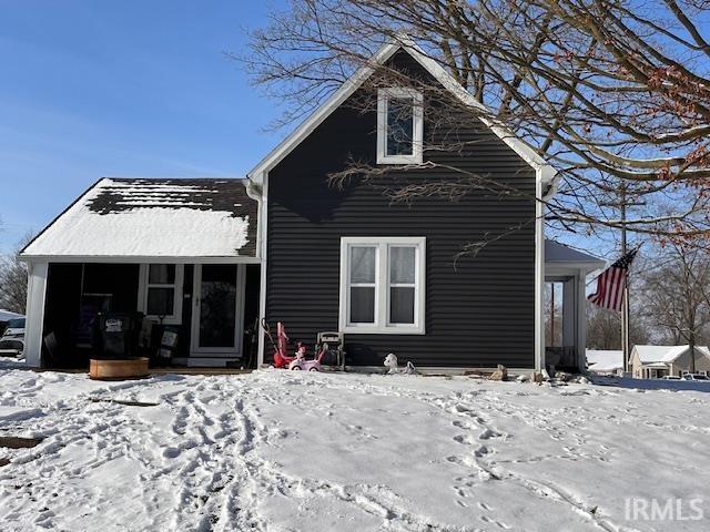 view of snow covered back of property