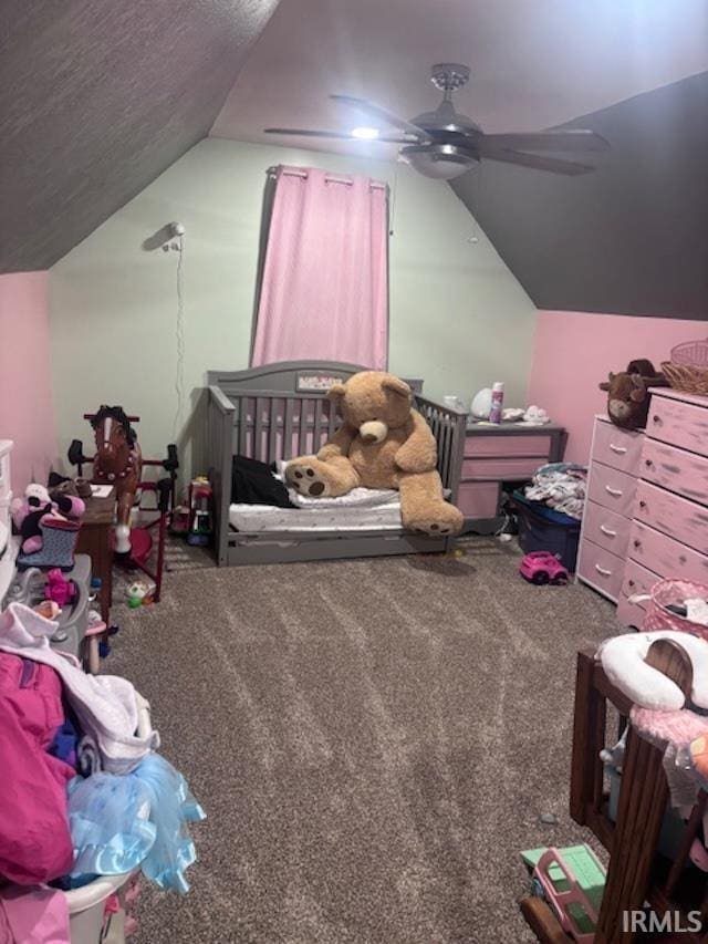 carpeted bedroom featuring a nursery area, ceiling fan, and lofted ceiling