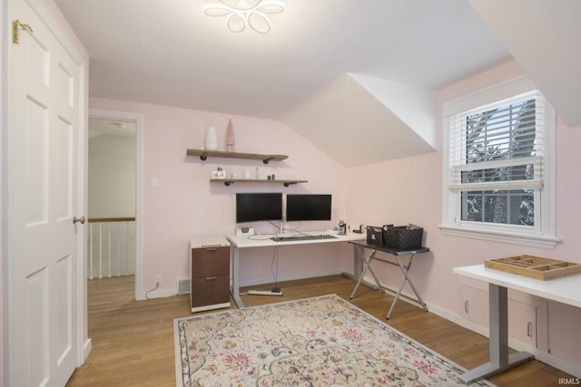 office with vaulted ceiling and light hardwood / wood-style flooring