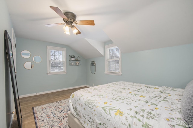 bedroom with ceiling fan, dark hardwood / wood-style floors, and lofted ceiling