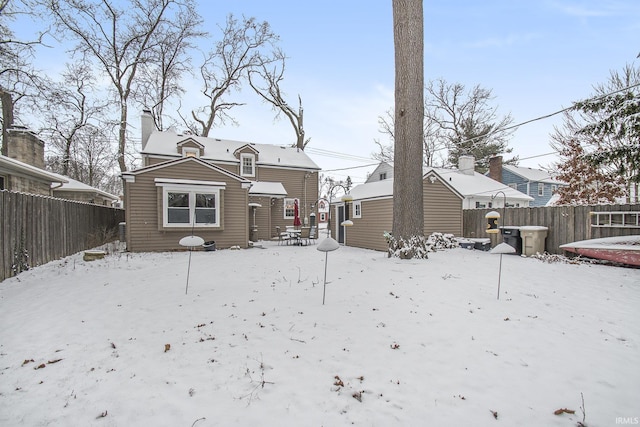 view of snow covered back of property