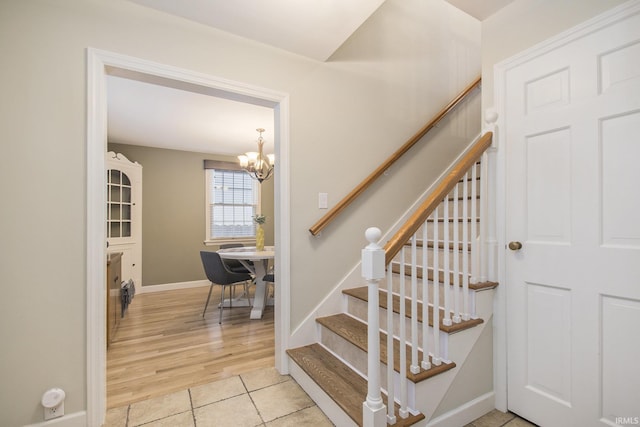 staircase featuring tile patterned floors and a chandelier