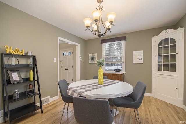 dining room featuring light hardwood / wood-style flooring and an inviting chandelier