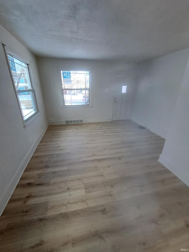 unfurnished room featuring a healthy amount of sunlight and light wood-type flooring