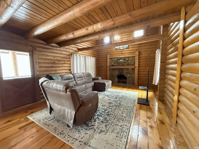 living room featuring beam ceiling, a stone fireplace, log walls, and light hardwood / wood-style floors