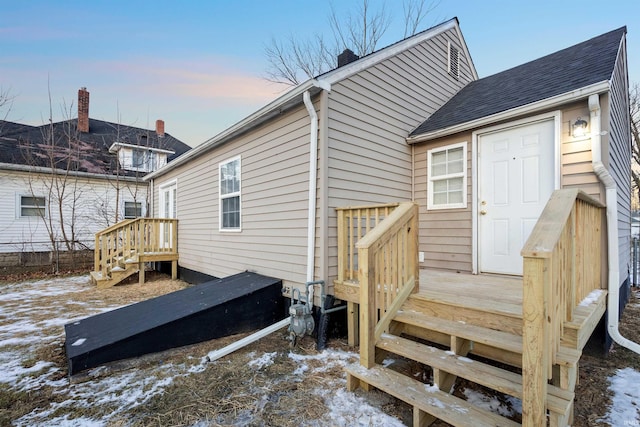 snow covered house featuring a wooden deck