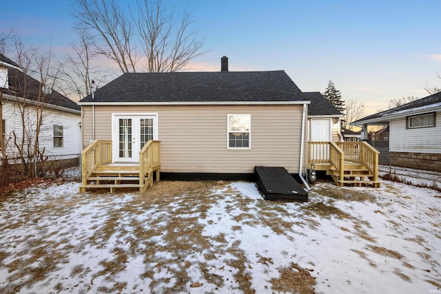 snow covered house with french doors