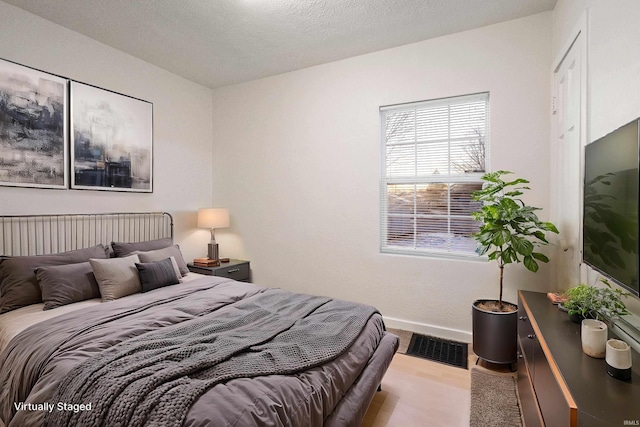 bedroom featuring wood-type flooring and a textured ceiling