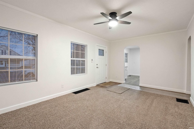 empty room with ceiling fan, carpet, and crown molding