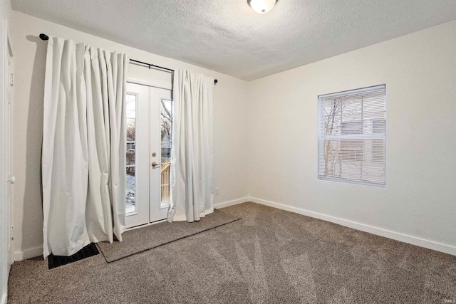 carpeted empty room featuring a textured ceiling