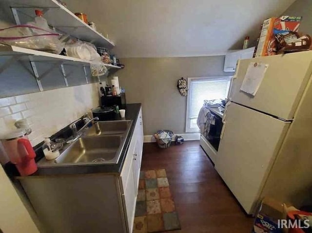 kitchen featuring decorative backsplash, sink, white refrigerator, white cabinets, and dark hardwood / wood-style floors