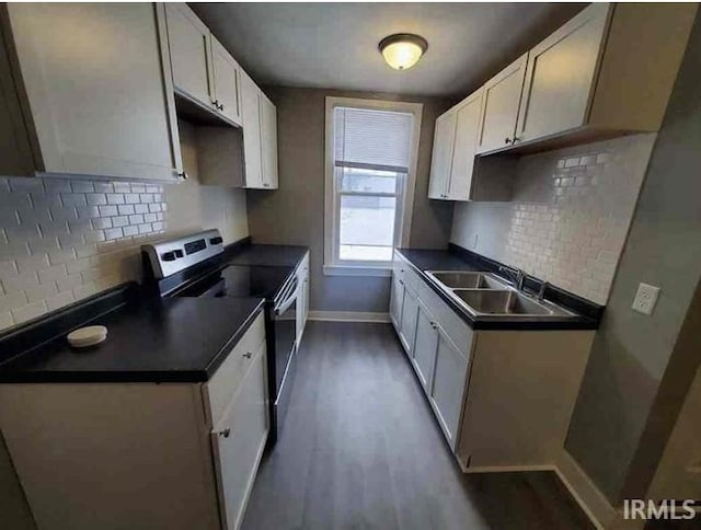 kitchen with electric range, dark hardwood / wood-style floors, white cabinets, and sink