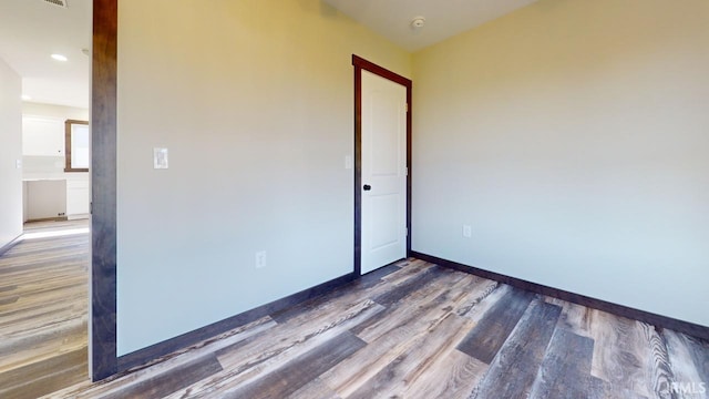 spare room with wood finished floors and baseboards