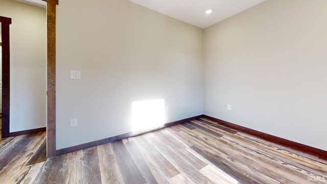 empty room with baseboards and wood finished floors