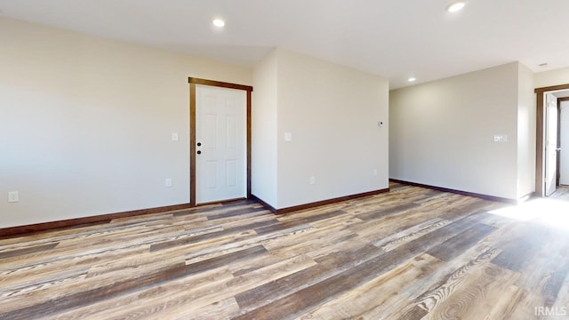 empty room with recessed lighting, light wood-style flooring, and baseboards