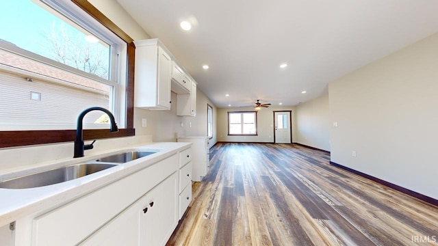 kitchen featuring light countertops, recessed lighting, light wood-style floors, white cabinets, and a sink