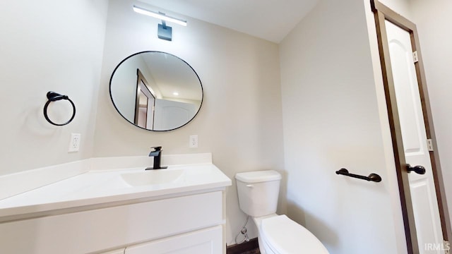 half bathroom with vanity and toilet