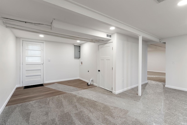 basement with hardwood / wood-style flooring and electric panel