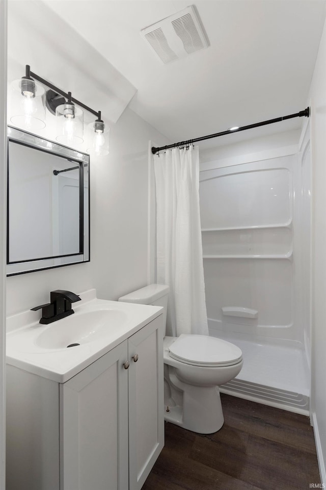 bathroom with wood-type flooring, a shower with curtain, toilet, and vanity