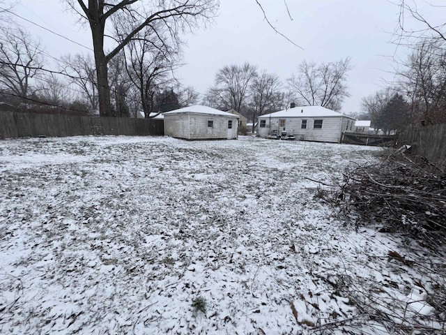 yard covered in snow with an outbuilding