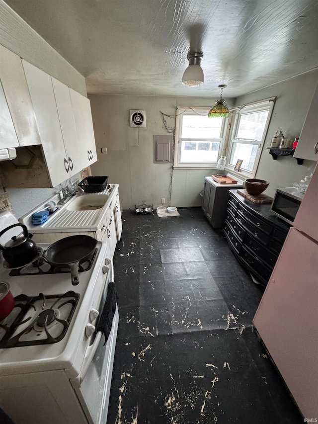 kitchen featuring visible vents, white range with gas stovetop, and stainless steel microwave