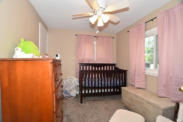 carpeted bedroom with a nursery area and ceiling fan