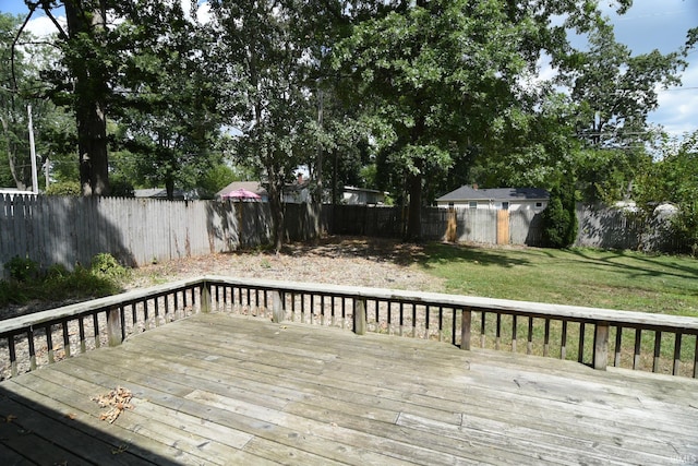 deck with a storage shed and a yard