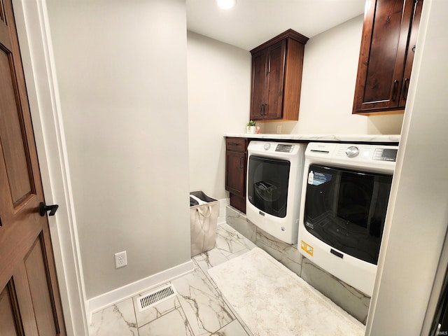 washroom featuring cabinets and separate washer and dryer