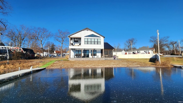 back of house with a water view and a balcony